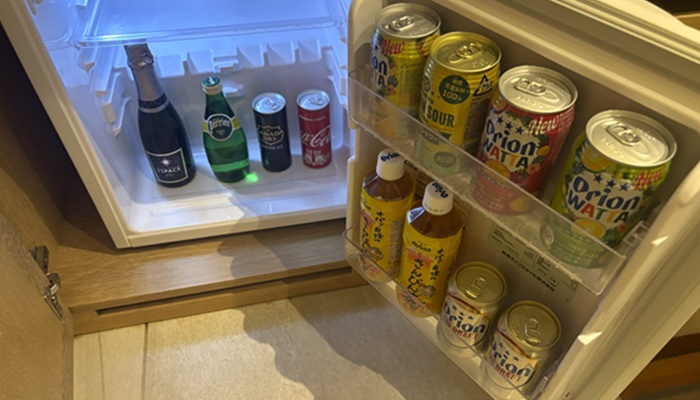 シギラミラージュ客室のミニバー冷蔵庫。オリオンビール、さんぴん茶、ジュースなどがぎっしり入った無料のドリンクサービス