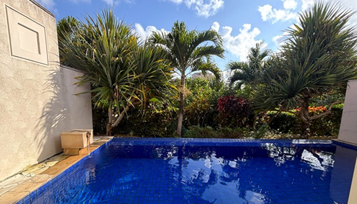 シギラミラージュ プールヴィラプレミアのプライベートプール。青いタイルに光が反射し、テラスから南国の植栽と青空を眺める風景