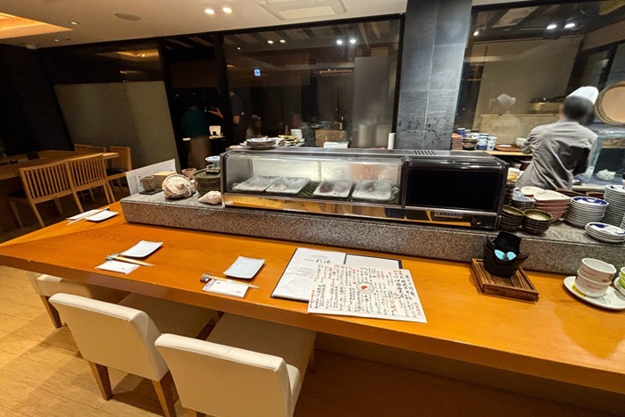 シギラミラージュ近くの蕎麦居酒屋「彩海」のカウンター席。美しい白木のテーブルと職人の手仕事が見える落ち着いた空間。